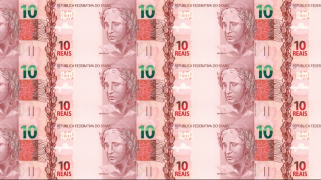 Series-of-banknotes-of-ten-brazilian-reals-of-the-bank-of-Brazil-rolling-on-screen,-coins-of-the-world,-cash-money,-loop