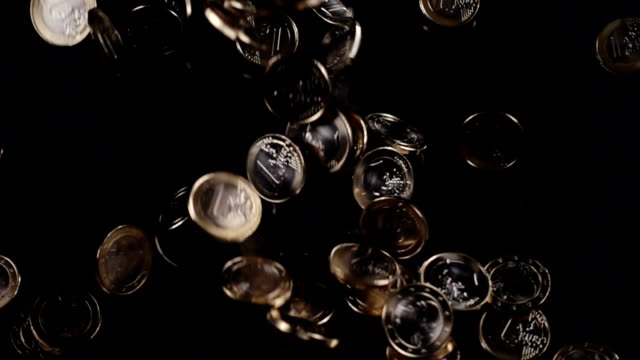 ein-Euro-Münzen-fallen-auf-schwarzem-Hintergrund