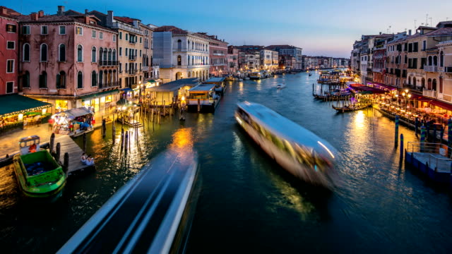 Grand-Canal-in-Venice,-Italy-day-to-night-timelapse.-View-on-gondolas-and-city-lights-from-Rialto-Bridge