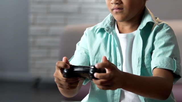 Biracial-male-kid-playing-video-games-at-home,-isolation-from-world,-friendless