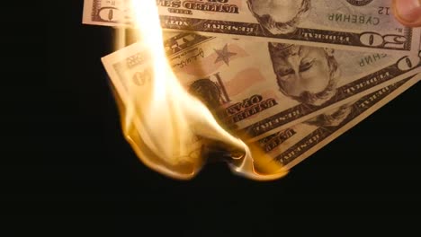 Brennende-Dollar-hautnah-auf-schwarzem-Hintergrund