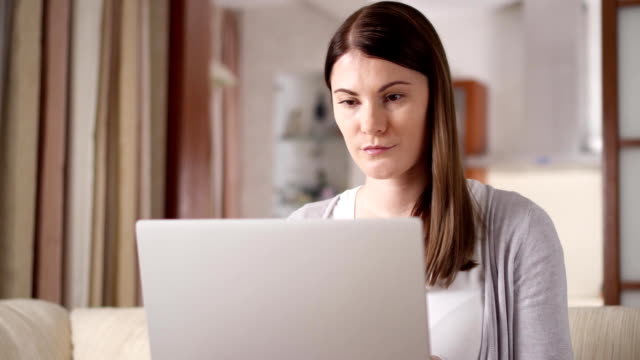 Attraktive-berufliche-lächelnde-Frau-auf-Laptop-Computer-zu-Hause-arbeiten.-Home-Office-Konzept