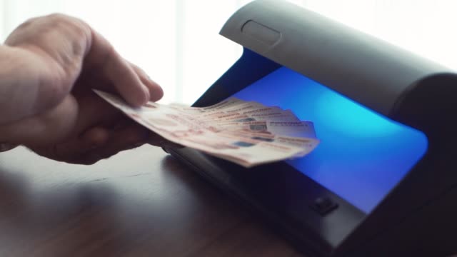 Geschäftsmann-Hand-überprüfen-fünf-Tausend-Rubel-Banknote-auf-UV-Licht-Detektor