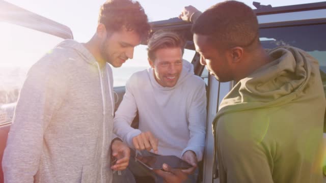 Drei-junge-Männer-mit-Tablet-PC-mit-ihrem-Auto