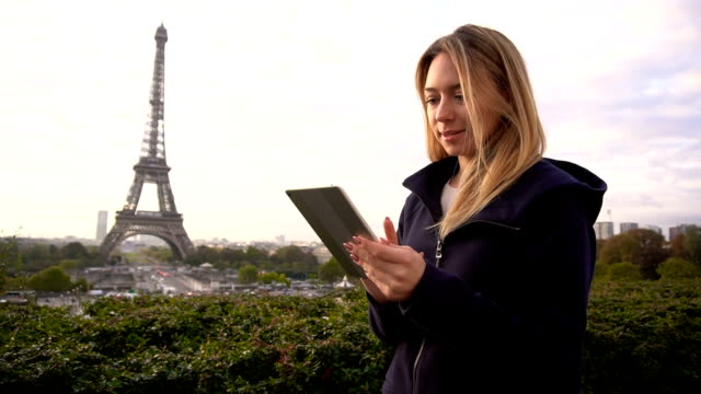 Gladden-weibliche-Person-Browsen-nach-Tablet-in-der-Nähe-von-Eiffelturm