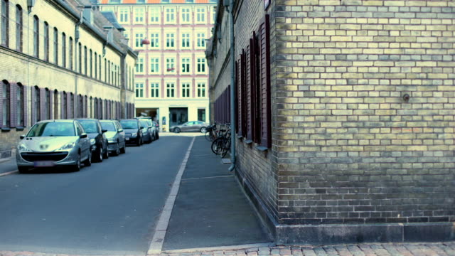 Viejas-calles-de-Copenhague-con-coches-y-bicicletas,-arquitectura-antigua,-historia