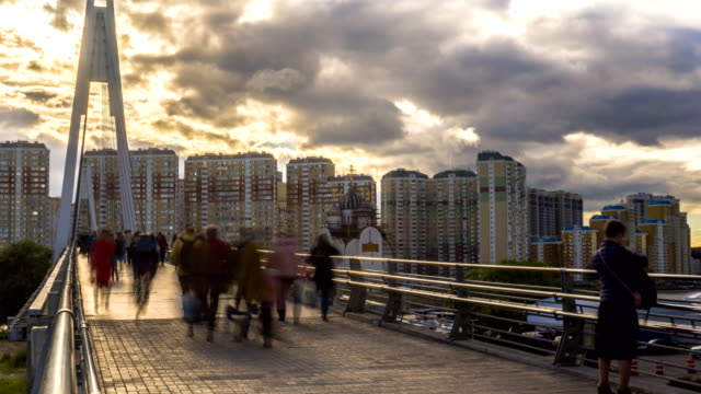 lots-of-people-walking-on-the-pedestrian-bridge-to-the-new-residential-area,time-lapse