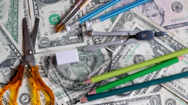 High-School-Kosten,-Konzept,-Bleistifte-auf-Geld,-Dollar,-drehen,-drehen,-von-oben