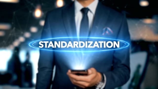 Businessman-With-Mobile-Phone-Opens-Hologram-HUD-Interface-and-Touches-Word---STANDARDIZATION