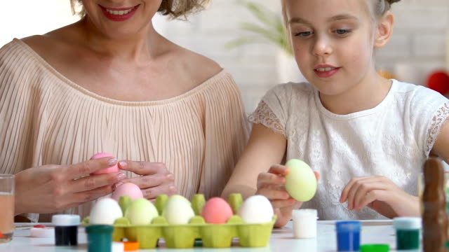 Mother-and-kid-packing-dyed-Ester-eggs-in-box,-giving-high-five-to-each-other