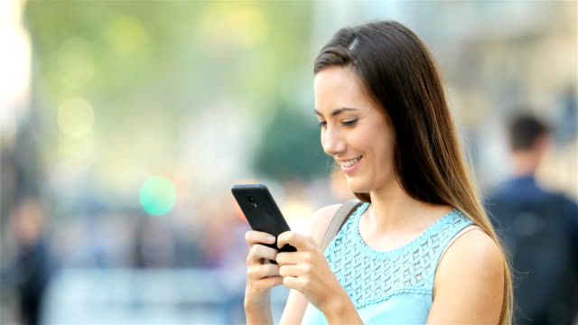 Glückliche-Dame-SMS-auf-Handy-draußen-auf-der-Straße