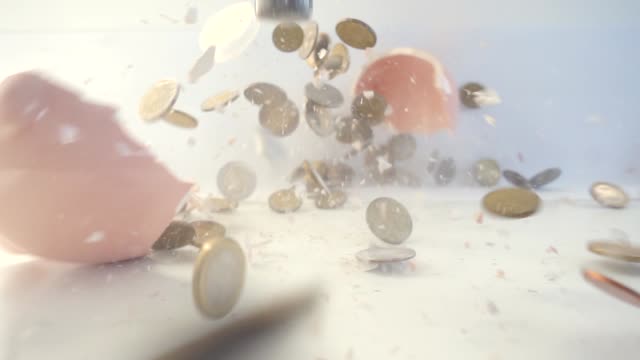 VIDEO-rosa-Sparschwein-mit-Cash-Einsparungen-mit-Hammer-auf-weißen-Tisch,-Slow-Motion-gebrochen