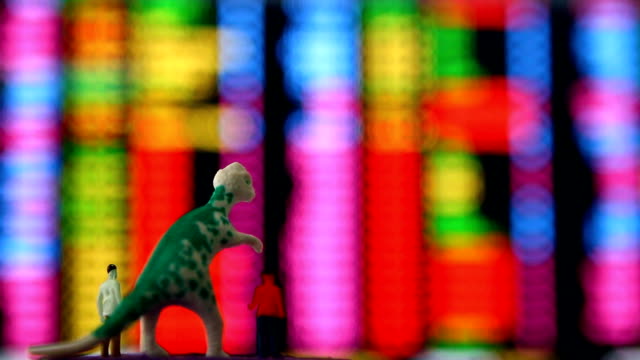 Dinosaur-and-men-doll-looking--stock-exchange-monitor