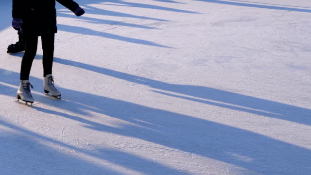 Multitud-de-personas-están-patinando-en-la-pista-de-hielo-en-el-día-soleado.-Cámara-lenta