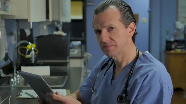 Enfermera,-médico-o-cirujano-masculino-usando-una-tableta-mirando-hacia-arriba-y-sonriendo