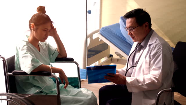 El-médico-senior-está-trabajando-para-explicar-los-detalles-de-la-enfermedad-para-el-paciente-que-está-sentado-en-la-silla-de-ruedas.