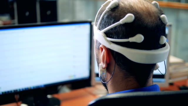 Monitor-mit-Informationen-aus-einer-EEG-Kopfhörer-setzen-auf-einen-Mann-übertragen