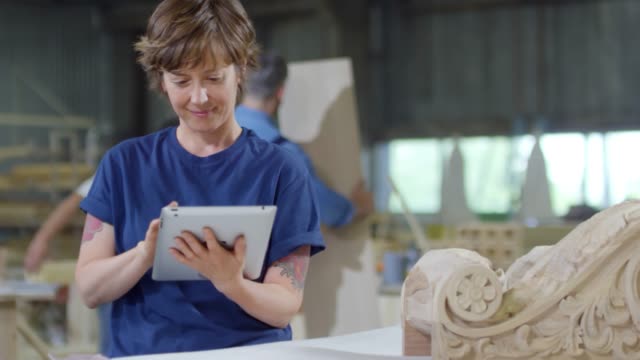 Mujer-usando-Tablet-en-carpintería-Shop