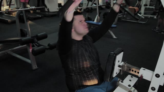 Hombre-gordo-alegre-realiza-un-ejercicio-equivocado-en-el-gimnasio.-Por-primera-vez-en-un-club-de-fitness