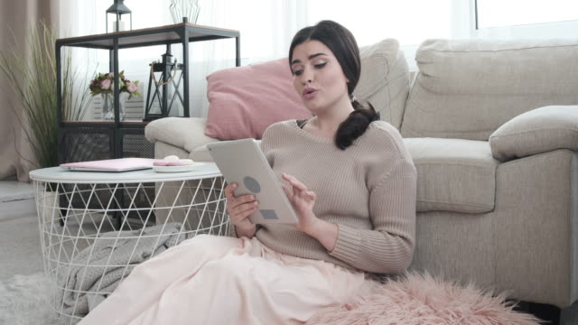 Mujer-divirtiéndose-usando-la-tableta-digital-en-casa