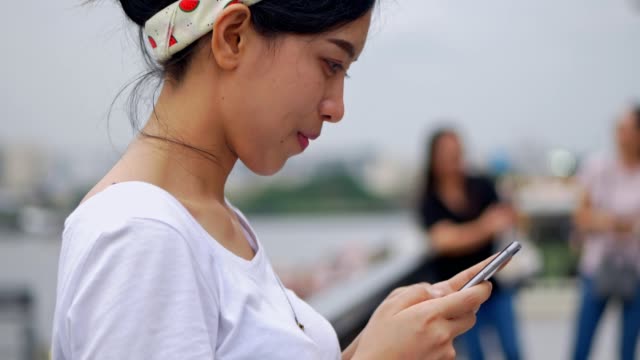 Schöne-junge-asiatische-Frau-mit-Smartphone-genießen-das-Lesen-von-sozialen-Medien.