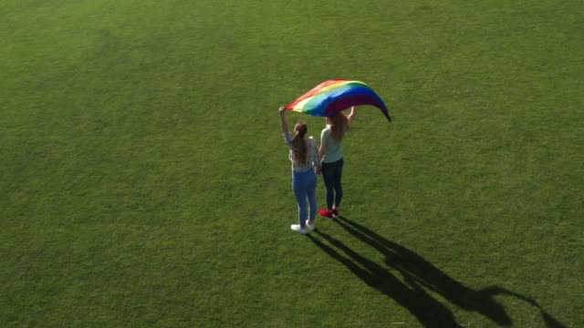 Drone-flight-over-gay-couple-holding-lgbt-flag