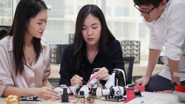 Group-of-electronics-engineer-try-to-fix-robot-at-lab.-Technology-and-innovation-concept.