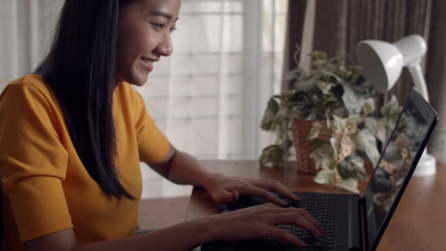 Retrato-de-atractiva-mujer-asiática-sonriendo-feliz-disfrutando-de-las-manos-escribiendo-usando-computadora-portátil-compartiendo-en-línea-blogger-influencer.-Comprar-en-línea-de-navegación-redes-sociales-de-comunicación-social.