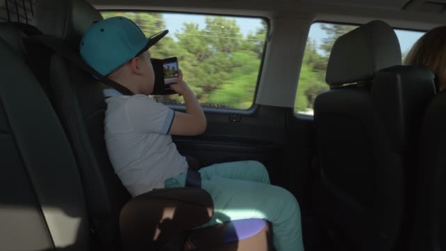 Niño-tomando-fotos-con-la-celda-cuando-viaja-en-coche