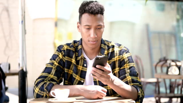 Joven-africano-usando-Smartphone,-Café-al-aire-libre