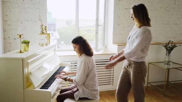 Freundinnen-lernen-Klavier-spielen-zu-Hause