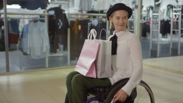 Stilvolle-paraplegische-Frau-im-Rollstuhl-Reiten-durch-Mall