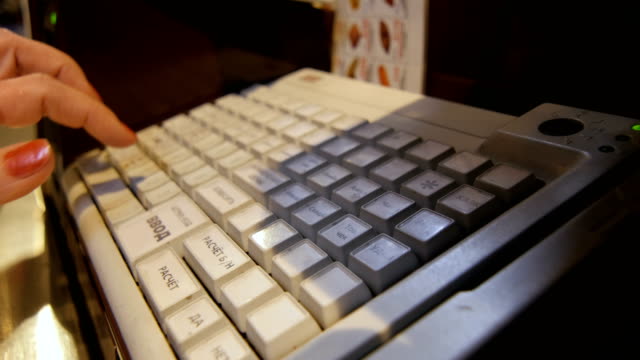 Side-View-Mujer-Cajero-funciona-en-la-máquina-con-teclado-blanco