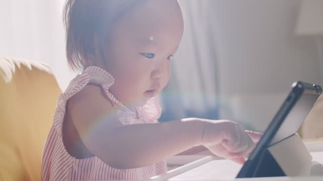 Asiatische-Baby-Mädchen-spielen-mit-digitalen-Tablet