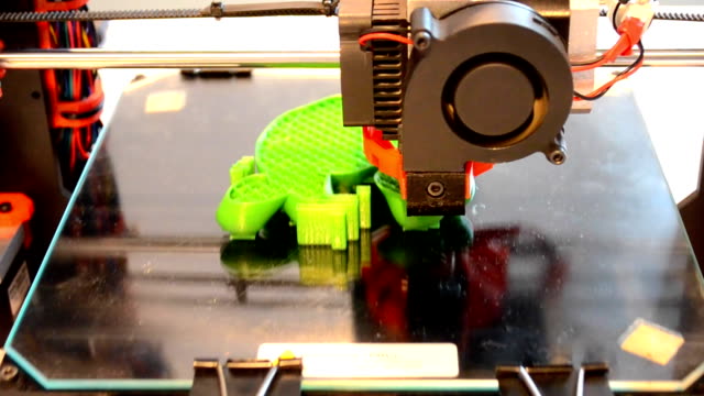printing-3D-printer-on-black-glass-surface-closeup