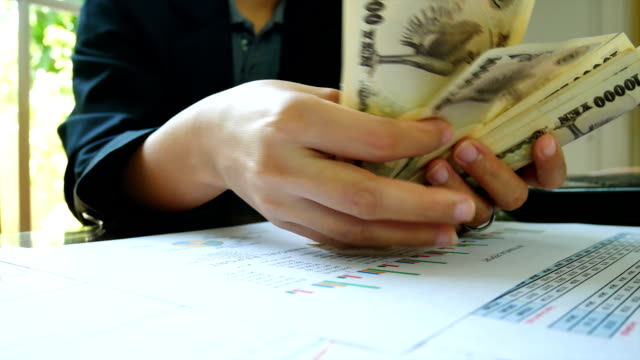 Close---up-working-woman--hand-count-money-with--financial-report-in-bussiness-and-financial-concept.