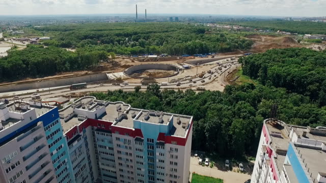 reconstruction-of-highway-and-traffic-circle-in-russian-city,-camera-moving-from-houses