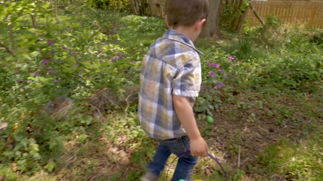 Camera-follows-a-young-cute-4---5-year-old-boy-finding-an-easter-egg