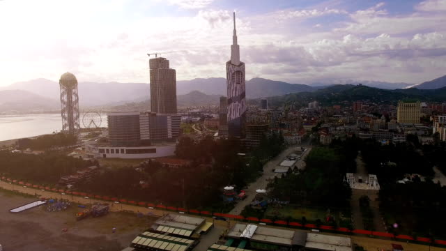 Batumi-downtown-in-light-haze-against-mountain-skyline,-early-evening-in-city
