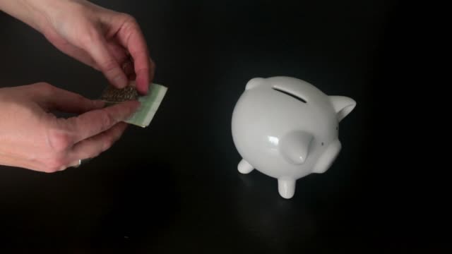 Frau,-eine-500-russische-Rubel-Banknote-in-ein-Sparschwein
