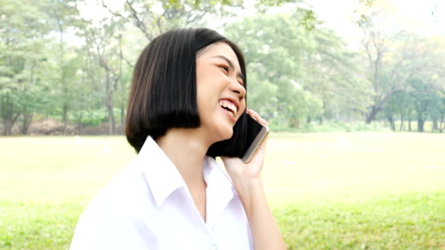 Asian-woman-using-smartphone-at-outdoor-park.-People-lifestyle-concept.