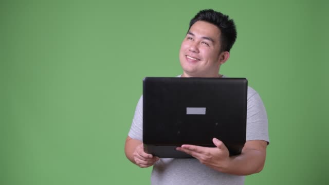 Junge-hübsche-Übergewicht-asiatischer-Mann-vor-grünem-Hintergrund