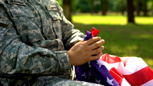 Armed-forces-hero-holding-american-flag,-memorial-service-for-war-victims