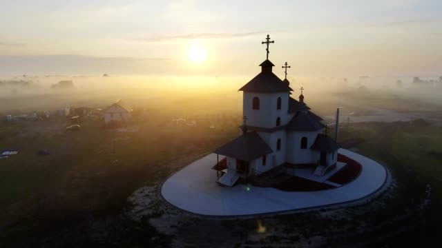 Video-de-imágenes-aéreas-de-la-iglesia-de-la-aldea-pequeña-en-la-mañana-brumosa.-Tiempo-del-amanecer.-Región-de-Kiev,-Ucrania.-Volando-sobre-el-río-de-Desna