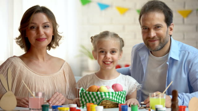 Glückliche-Familie-posiert-auf-Kamera-mit-Osterkorb,-uralte-Tradition,-Feier