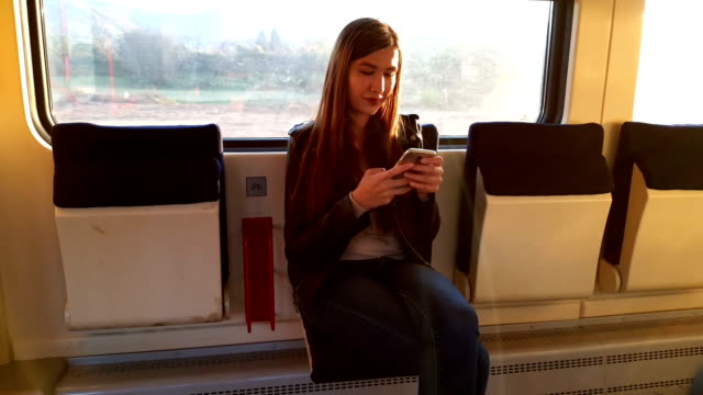 Mujer-en-el-tren-con-el-teléfono-inteligente