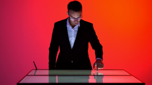 Der-Geschäftsmann-arbeitet-mit-einem-Touchscreen-im-roten-Raum
