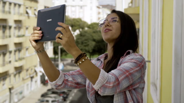 Glückliche-junge-Frau-in-Brillen-mit-Videoanruf-über-Tablet.