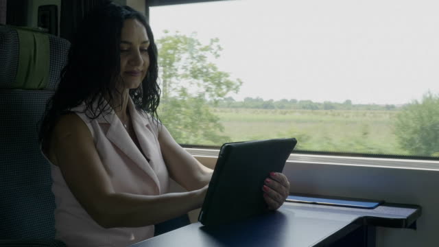 Attraktive-fröhliche-Passagierfrau-genießt-Reise-im-Chat-in-sozialen-Netzwerken-mit-Tablet-PC,-während-sie-allein-reist