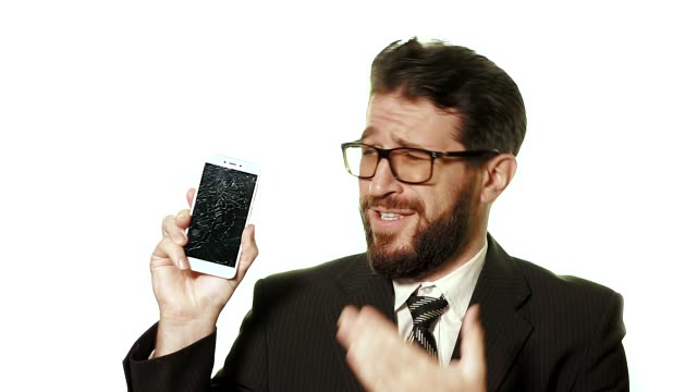 El-concepto-de-un-gadget-roto.-Hombre-de-negocios-barbudo-con-gafas-muestra-un-teléfono-móvil-de-pantalla-rota,-él-es-caricaturizado-molesto-y-ofendido.